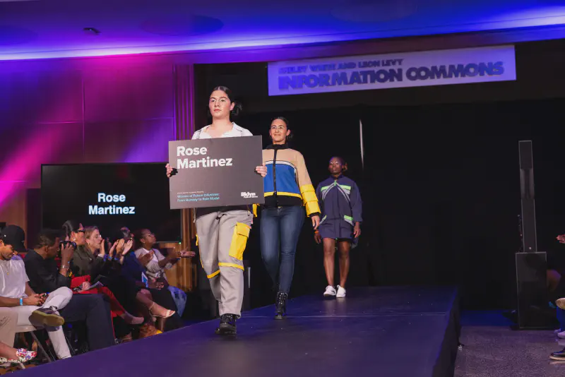 Models walking down the runway with my name on a poster board.